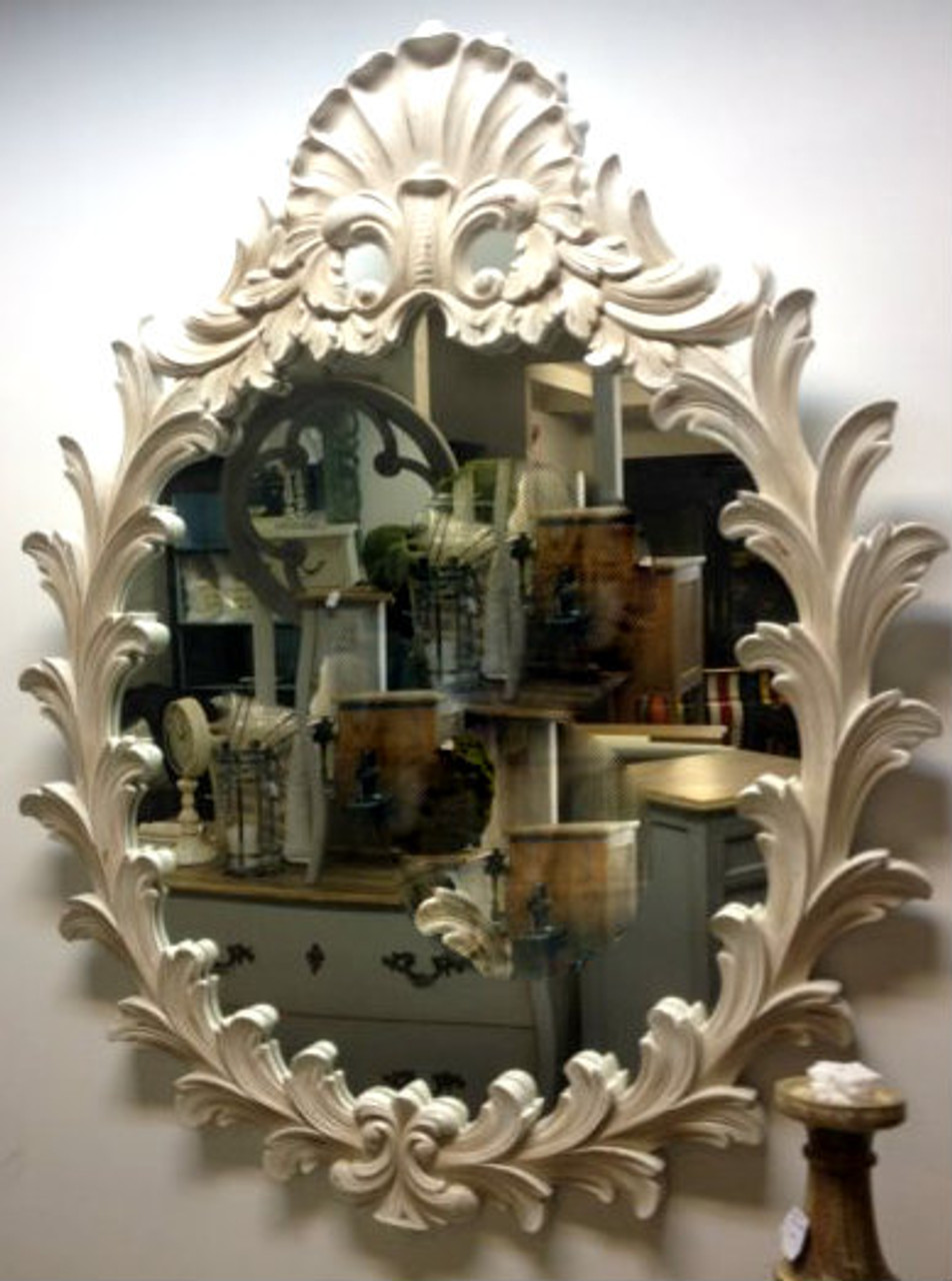 Close-up of the mirror's intricate carvings, emphasizing the craftsmanship and French-inspired design elements in a well-lit setting.