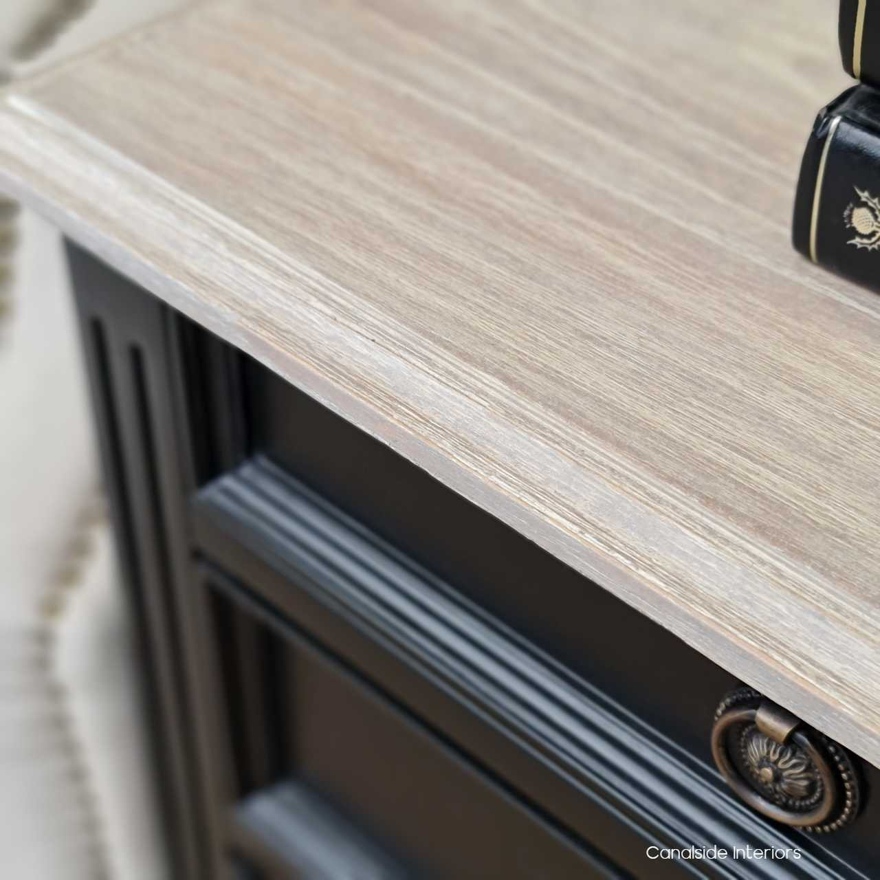 The bedside table's limewash top detail, offering a unique texture and contrast against the black finish.
