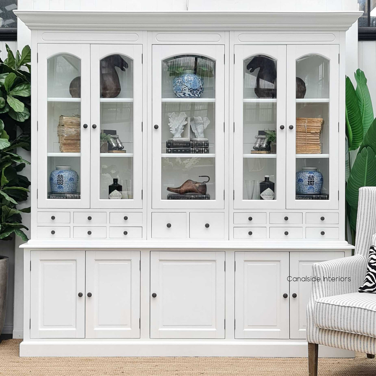 Perfect for showcasing cherished collectibles, the Key Largo Display Unit's white distressed finish complements a modern, elegant home – Canalside Interiors.