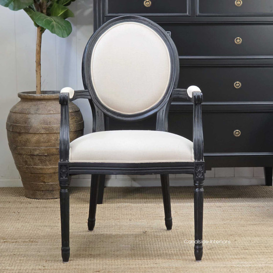 Angled profile capturing the smooth matte-black frame paired with refined cream upholstery.