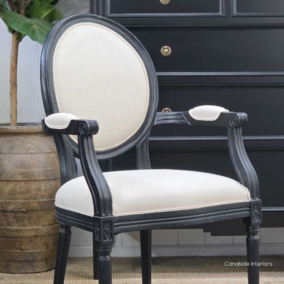 Angled profile capturing the smooth matte-black frame paired with refined cream upholstery.