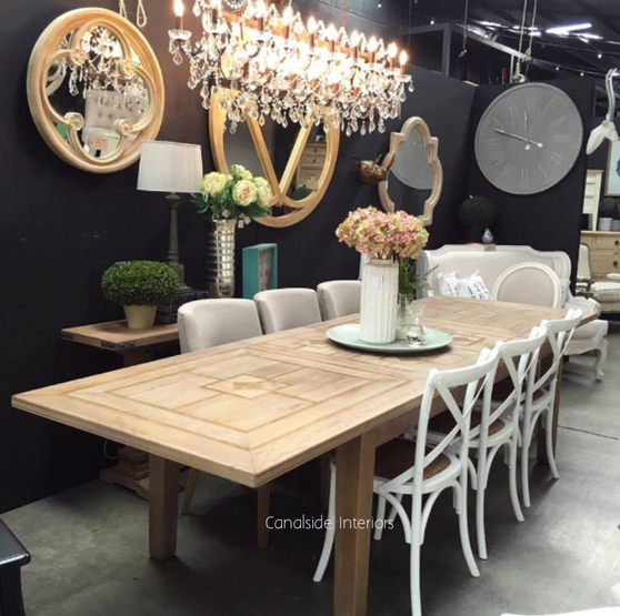 A well-lit image showcases the Rococo Chandelier as a centerpiece in a coastal-inspired living room, where lighting is not just functional but a statement of art