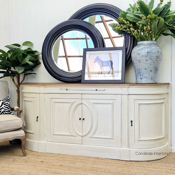 The Bastian Large Sideboard's stone finish and weathered oak top blend traditional French design with a Hamptons-style flair, offering a sophisticated storage solution for your living room