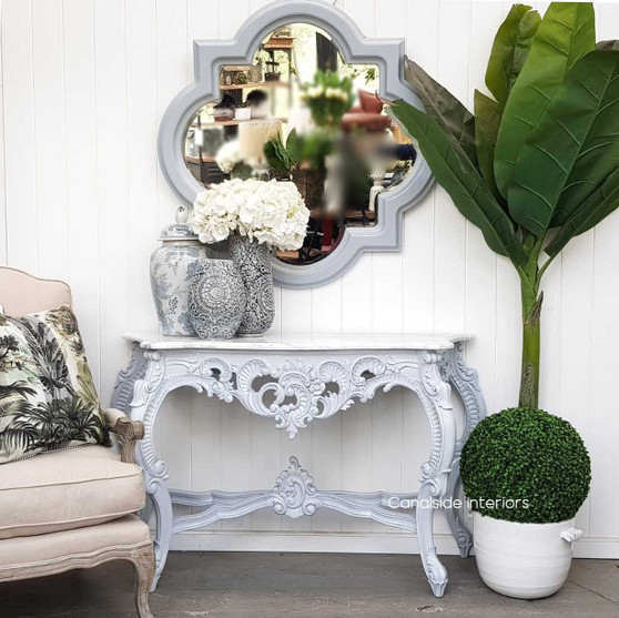 The Classic Grey Baroque Marble Console by Canalside Interiors, elegantly poised by the living room wall, reflects a timeless Hamptons aesthetic