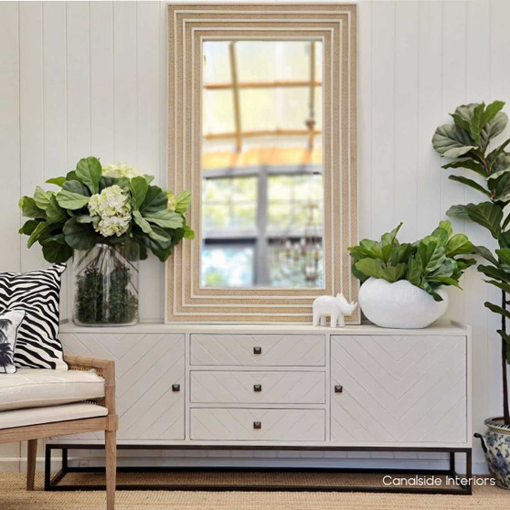 Side perspective of the rectangular mirror, highlighting the depth and texture of the rattan against the distressed stone.
