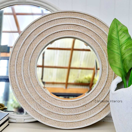 Frontal view of the Brielle Rattan Round Mirror Small at Canalside Interiors, showcasing its distinctive distressed stone frame and intricate rattan detailing.