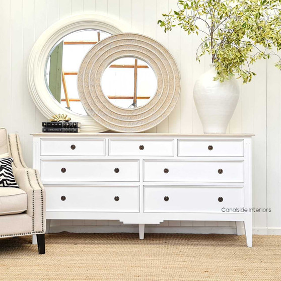 View of the Aspen Mirror at Canalside Interiors, showcasing its classic round design and distressed white finish.