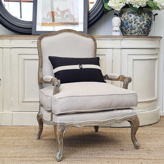 View of the Catelyn Armchair in cream, positioned as a sophisticated centerpiece in a Hamptons-style living room.