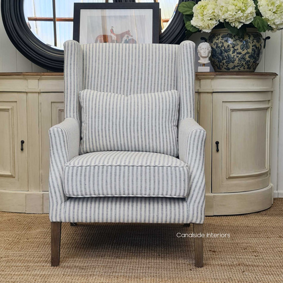 View of the Bayview Occasional Wingback Armchair at Canalside Interiors, highlighting its blue striped linen blend upholstery and classic silhouette.