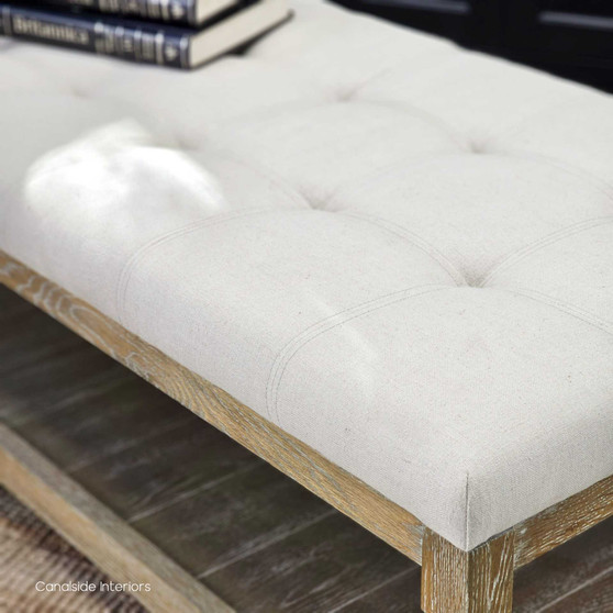 Elegant front view of the Providence Tufted Coffee Table Ottoman, showcasing the cream linen blend upholstery and weathered oak frame in a light-filled lounge room.