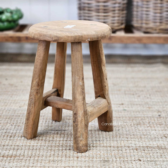 Side angle of the Vintage Teak Round Stool, highlighting its sculptural form and rustic texture.