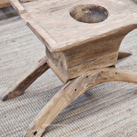 Side angle of the Vintage Teak Lumpang Coffee Table, highlighting the curved wooden legs and rustic hand-carved details.