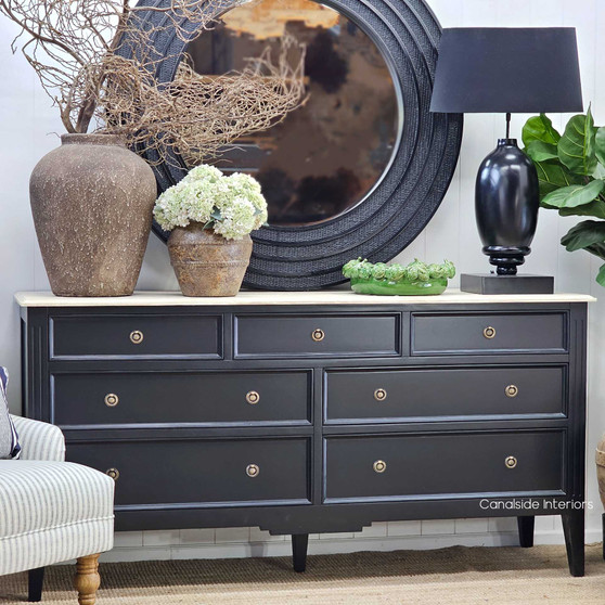 View of the chest styled with a round mirror and decorative ceramics, creating a polished Hamptons-inspired look.