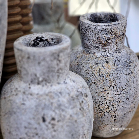 Side angle of two Kirana vessels with succulent stems, styled with natural elements to complement their earthy finish.