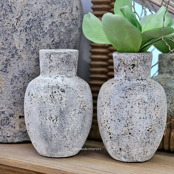 Side angle of two Kirana vessels with succulent stems, styled with natural elements to complement their earthy finish.