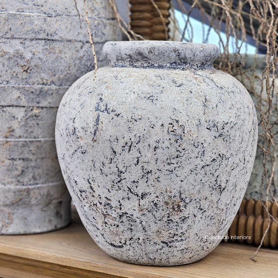 Full view of the Noema Terracotta Pot Vessel styled with white florals, showcasing its rounded form and textured stonewash finish.
