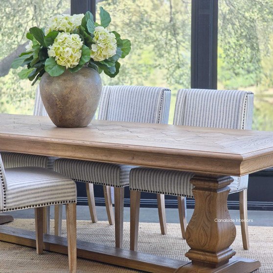 Vignette detail of the table paired with classic chairs.