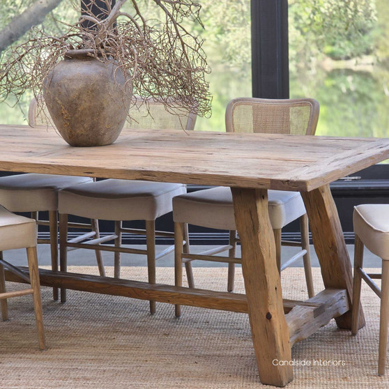 Side view of the Hollowgrove Reclaimed Dining Table showcasing its rustic angled-leg base and natural timber grain.