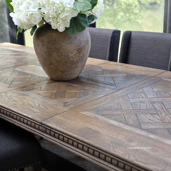 Berenson Cigar oak table in formal dining setting with upholstered chairs 