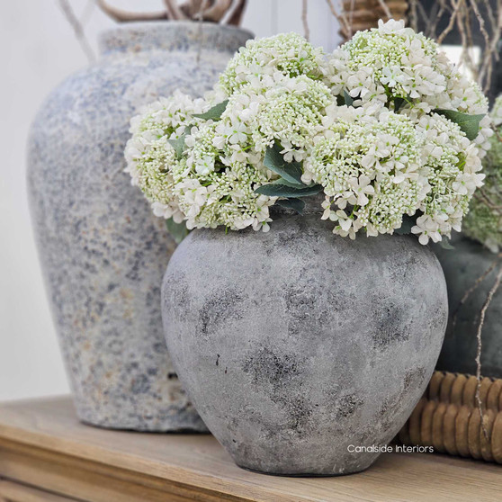 Styled scene featuring the Tala Pot Vessel in smooth rustic stone stylewash with natural greenery.