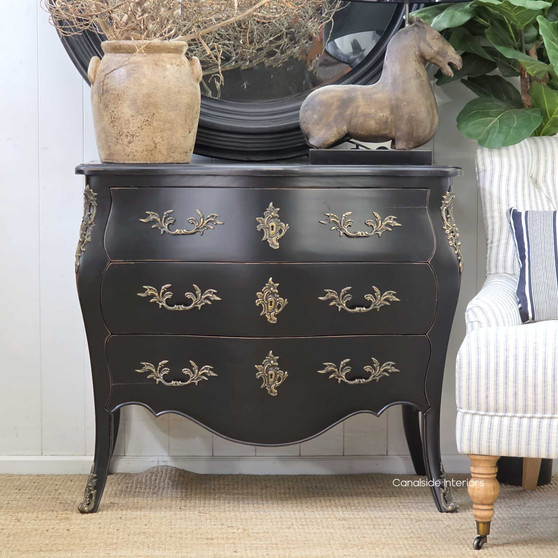 Shot of the chest styled in a hallway with vintage décor, adding bold colour and personality.