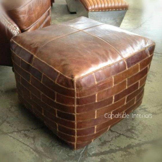 The Aged Leather Brick Motif Ottoman from Canalside Interiors exudes a classical Hamptons style, perfect for adding a coastal vibe to your bedroom with its rich brown color and timeless design