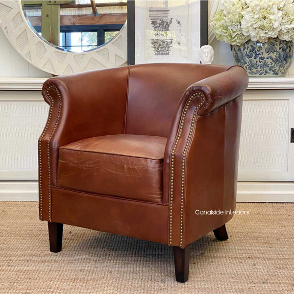 Enrich your living room with the timeless appeal of the Cox & King Aged Leather Tub Chair from Canalside Interiors, a testament to quality craftsmanship and coastal luxury.