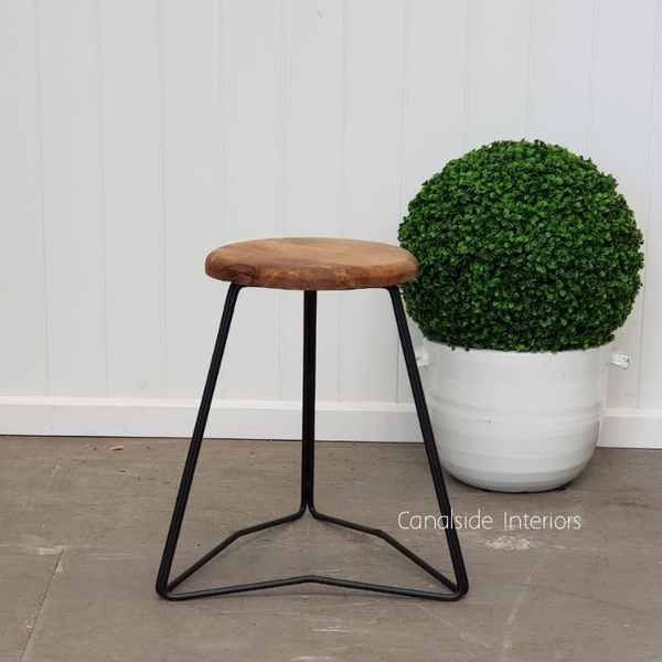 Pippa Low Stool in distressed black with a wooden seat, showcasing minimalist design in a Hamptons-style interior.