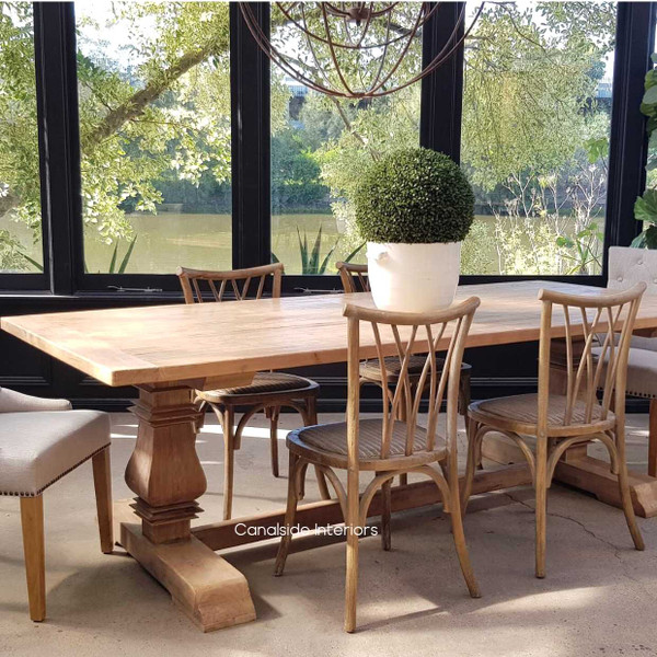 Front view of the Artisan Dining Table at Canalside Interiors, showcasing its recycled timber construction and hand-carved pedestal legs.