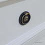 lose-up of the decorative hardware with textured beading on the bright white drawer front.