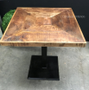 Close-up on the table's handcrafted mangowood top, highlighting the natural grain and texture.