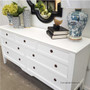 The sideboard's white finish contrasted against a crisp white wall color, showcasing its ability to complement various interior color schemes.