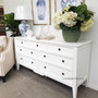White 7-drawer chest shown from a slight angle to emphasise the subtle detailing and classic silhouette of the piece