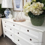 White 7-drawer chest captured in a left three-quarter view, presenting depth, structure and timeless craftsmanship.