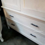 Close-up of the elegant brass handles against the distressed stone, adding a touch of luxury to the functional design.