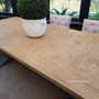 The beauty of the Balmoral Table's weathered oak top captured in natural light, exuding an air of coastal tranquility.
