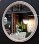 Round Raffles Cane Mirror in distressed stone, exuding classical elegance in a modern living room
