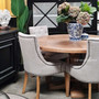 Styled shot in a light-filled dining space, showing how the round table complements both modern and coastal decors with its natural wood tones.