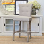 The stool positioned in a modern Hamptons decor, illustrating how it beautifully accentuates the space with its neutral cream upholstery and adds sophistication to modern and timeless decors.