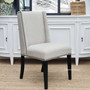 Frontal view of the Leclerc Dining Chair at Canalside Interiors, showcasing its cream upholstery and textured black legs against a modern Hamptons-style dining room backdrop.