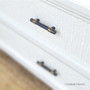 Detail of the wardrobe's elegant brass handles against the distressed white finish, adding a touch of luxury.