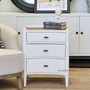 The Tweed Hill Rattan Bedside in distressed white, showcasing its unique concave face and rattan top, set against a neutral bedroom backdrop.