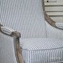 Detail of the armchair's striped upholstery, emphasizing the quality and sophistication of the linen blend fabric.