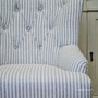 Elegant Ascott Armchair with tufted button detailing, providing a classic touch to a modern coastal living room.