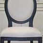 Distressed black Sansa Dining Chair with cream upholstery adds French-inspired elegance to a Hamptons-style dining area - Canalside Interiors.