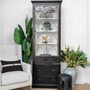 The Wessex Display Cabinet standing tall in a living room, showcasing its distressed charcoal/black exterior against a minimalist decor.