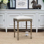 Front view of the Caylee Kitchen Stool, showcasing its classical cream linen upholstery that complements any modern kitchen island