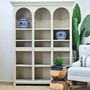 Biblioteque Arched Open Bookshelf front view in a bedroom, showcasing the distressed sesame texture - a modern twist on Hamptons elegance.
