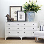 The white Camille Chest beside a lounge chair, underlining its functionality as an elegant and modern storage solution