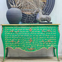 Front-facing image of the Piccini Commode, highlighting its vibrant green finish, sweeping bombe silhouette, and poetic gold script.